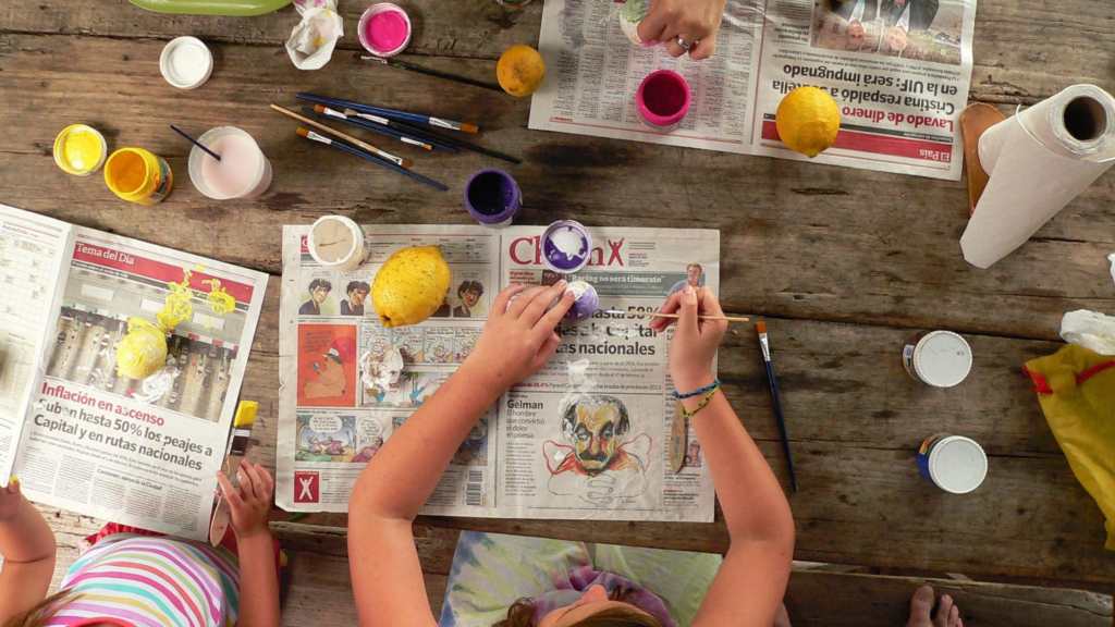 Kids sat at table doing arts and crafts